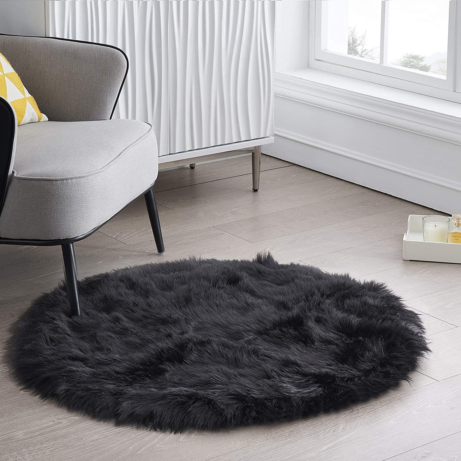 Round Rug Fuzzt Black round sheep fur area rug under a chair
